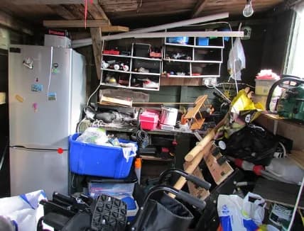 A cluttered garage interior — the kind of cleanout Aldo Unlimited tackles on a junk removal job.